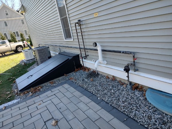 A brand new air conditioning condenser unit on the side of a house.