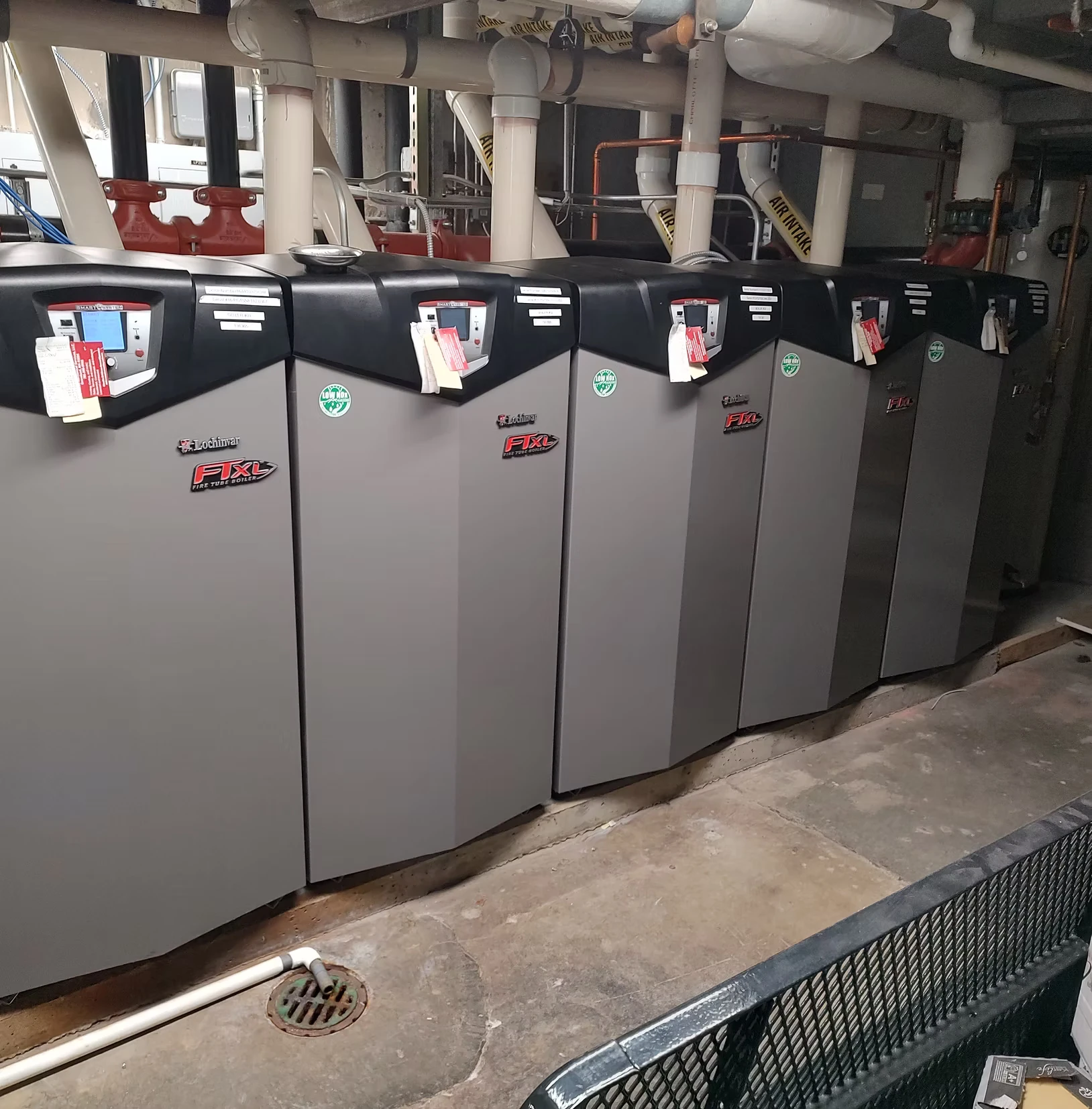 A picture of 5 commerical grade Lochinvar boilers in a row in a mechanical room