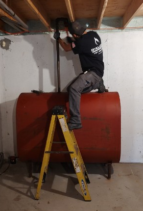 Charlie working on an oil tank